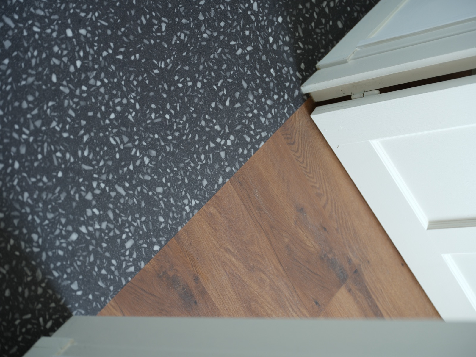 Détail de la jonction coupée à la lame entre terrazzo et parquet, sans seuil